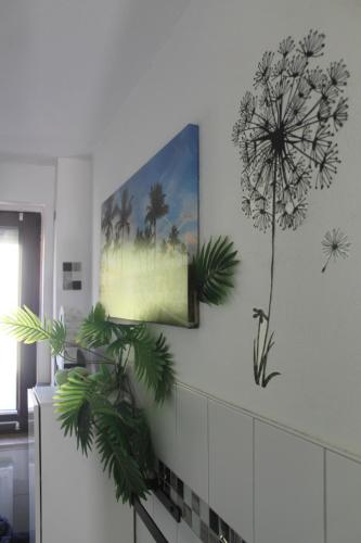 eine Wand mit einem Gemälde und Pflanzen darauf in der Unterkunft Ferienwohnung Zum Vierbeiner in Pirna
