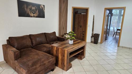 a living room with a brown couch and a table at Fewo-OPR de Billi in Wusterhausen