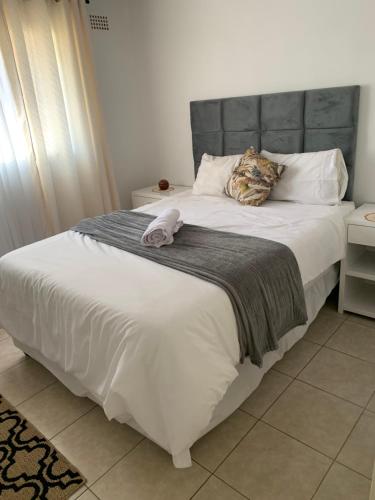 a large white bed with a stuffed animal on it at ShanazNest in Bulawayo