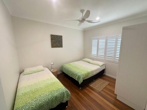 a bedroom with two beds and a ceiling fan at Three Fifty Four Straight St Hat Head - Bring your own linen. in Hat Head