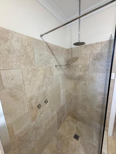 a bathroom with a shower with a glass door at Three Fifty Four Straight St Hat Head - Bring your own linen. in Hat Head