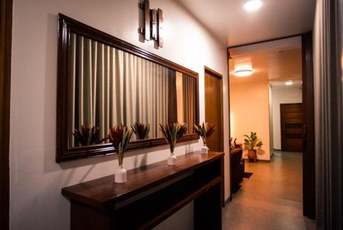 a hallway with a counter with flowers in a mirror at Balay Salazar in Malolos