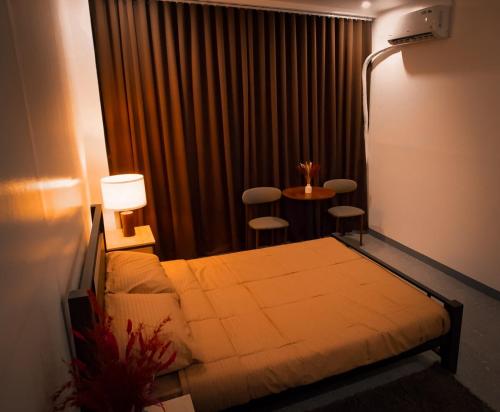 a hotel room with a bed and a table and chairs at Balay Salazar in Malolos