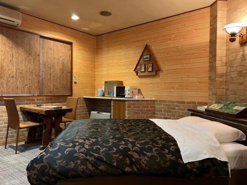 a bedroom with a bed and a desk and a kitchen at adult only ホテルシャルム in Itoigawa