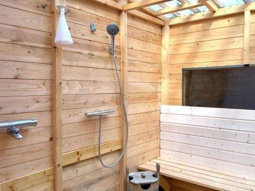 a bathroom with a shower in a wooden wall at Tree Tents Camping Linnansaari in Savonlinna