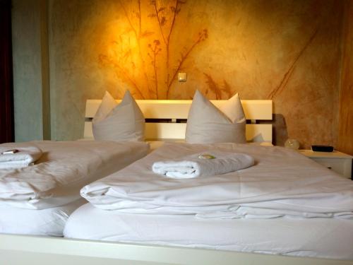 a bedroom with two white beds with towels on them at Ferienwohnungen Am Butterturm in Bad Langensalza