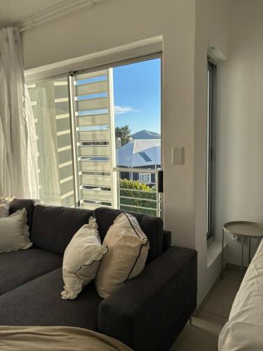 a living room with a couch and a large window at M&M Nest in Windhoek