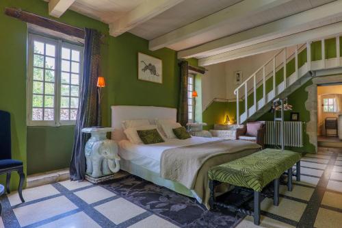 a bedroom with green walls and a bed and a staircase at Le Mas D'alzon in Vagnas