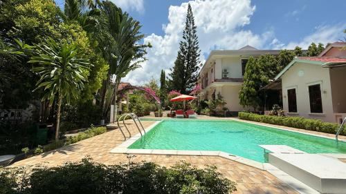 a swimming pool in front of a house at Hiep Thanh Resort in Phú Quốc
