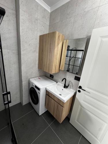 a laundry room with a washing machine and a sink at Ak Suites Rezidans in Trabzon