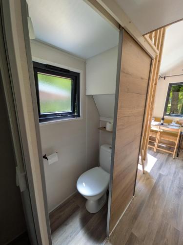 a small bathroom with a toilet and a window at Tiny house in Saint-Côme-dʼOlt