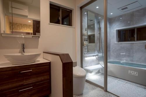 a bathroom with a toilet and a sink and a shower at Comlien Villa Resort in Tateyama