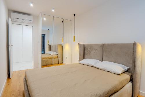a bedroom with a large bed and a mirror at K16 Apartments in Krakow