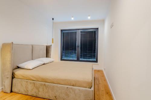 a bed in a room with a window at K16 Apartments in Krakow