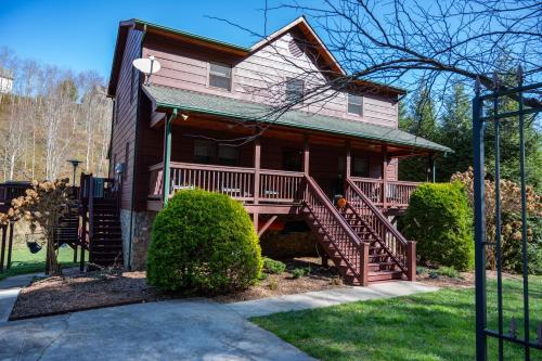 a house with a porch and stairs to the front of it at Riverbend Retreat in Todd