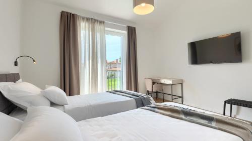 a hotel room with two beds and a television at Villa Moia by Villas Guide in Kaštelir