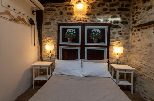 a bedroom with a large bed with two tables at La Casetta nel Borgo in Montalbano Elicona