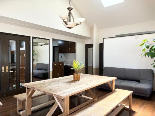 a living room with a wooden table and a couch at 禮 -Rei House- in Muromimachi
