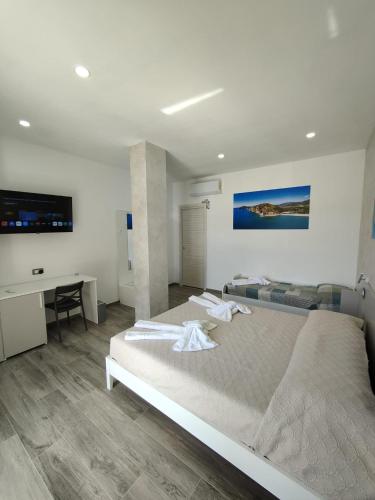 a bedroom with a large bed and a desk at Blue Cave b&b in Palinuro