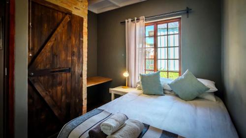 a bedroom with a bed with a door and a window at Studios @ Delver in Parys