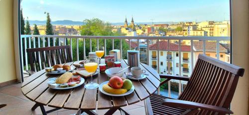 a wooden table with food and drinks on a balcony at Hotel Carlos V in Granada