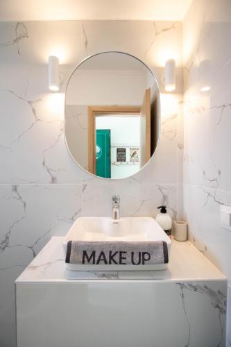 a white bathroom with a mirror and a sink at Ladina Comfort Studios in Lygia