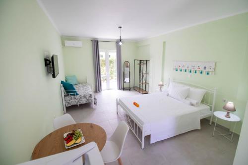 a living room with a white bed and a table at Ladina Comfort Studios in Lygia