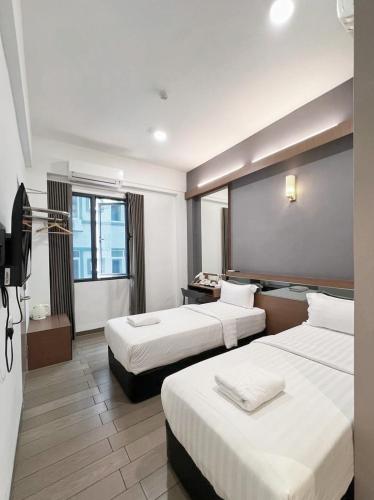 a hotel room with two beds and a television at Hotel Golden View Nilai in Nilai