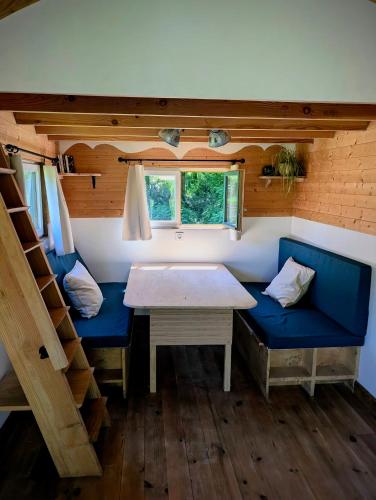 a dining room with a table and benches in a tiny house at Tinyhouse insolite - Au bout du chemin - 10 min de Foix in Baulou