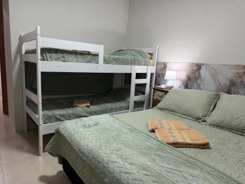 a bedroom with two bunk beds and a bed at Sobrado NOVO próximo BR 290 in São Gabriel
