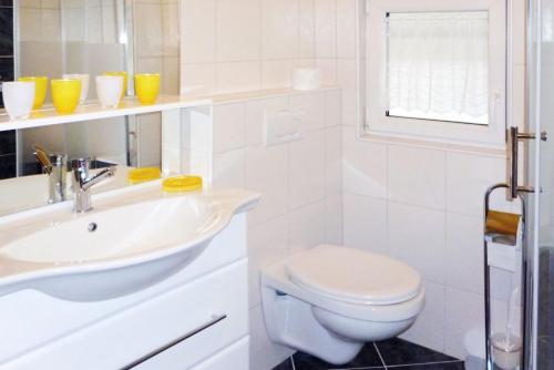 a white bathroom with a toilet and a sink at Haus Bauer Ferienwohnung 1 in Wasserburg