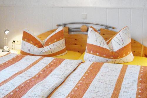 a bedroom with two beds with orange and white sheets at Haus Bauer Ferienwohnung 1 in Wasserburg