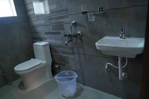 a bathroom with a toilet and a sink at Hotel Vijaya Comfort in Hyderabad