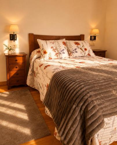 a bedroom with a bed and a night stand with two lamps at Casa das Minas in Zobra