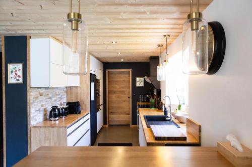 a kitchen with white cabinets and a wooden counter top at Ouréa in Génos