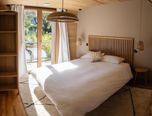 a large white bed in a bedroom with a window at Ouréa in Génos