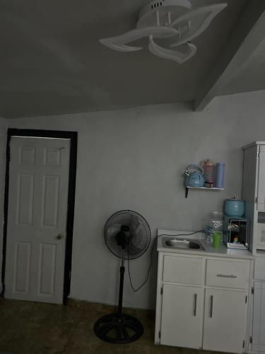 a kitchen with a fan in the corner of a room at Acogedor estudio cerca del aeropuerto in Tijuana
