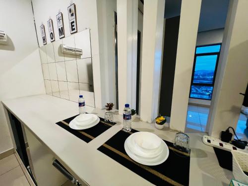 a bathroom with two white plates on a counter at Comfort Zone Premium Guesthouse @ Evo Bangi in Bangi