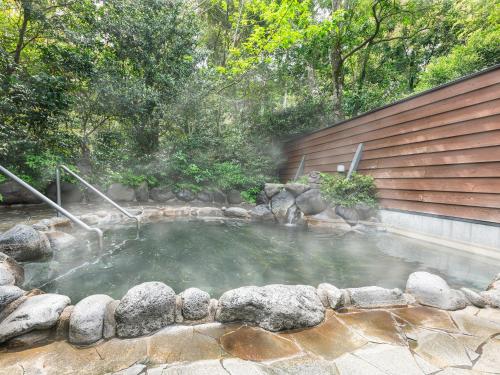 a pool of water with rocks in a backyard at Hotel Kirishima Castle in Kirishima