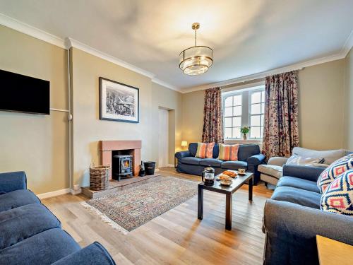 a living room with blue couches and a fireplace at High Dougarie Farmhouse in Dougarie