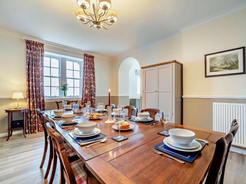 a dining room with a large wooden table and chairs at High Dougarie Farmhouse in Dougarie