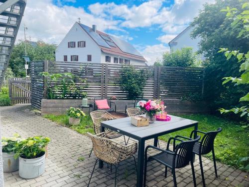 a patio with a table and chairs and a fence at Appartement Morgensonne in Egling
