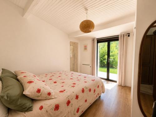 a bedroom with a bed and a large window at Authentique maison en pierre blanche du Quercy in Castelnau-de-Montratier