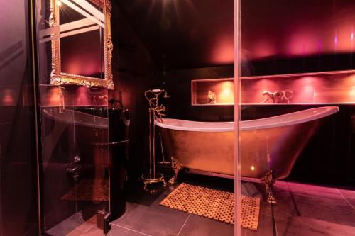 a bathroom with a copper tub and a mirror at Les Secrets Rooms - Verdun in Verdun-sur-Meuse