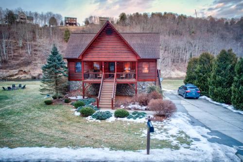 a log cabin with a car parked in front of it at River Roost in Todd