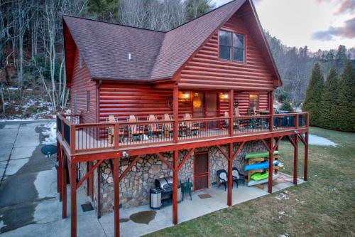 a log cabin with a deck and a porch at River Roost in Todd