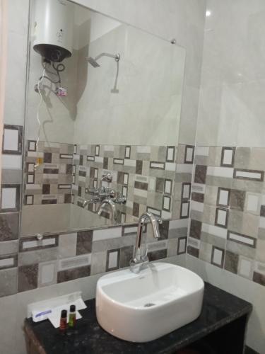 a bathroom with a sink and a mirror at The Kalindi Hotel and Resort in Hamīrpur