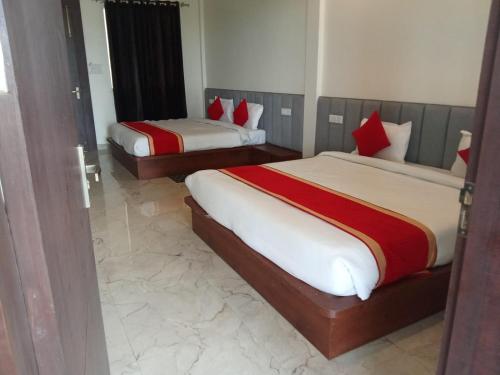 a bedroom with two beds with red pillows at The Kalindi Hotel and Resort in Hamīrpur
