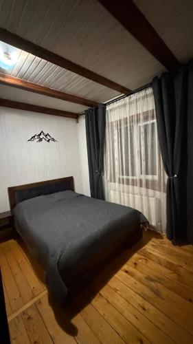 a bedroom with a bed in a room with a window at Arkan in Mykulychyn