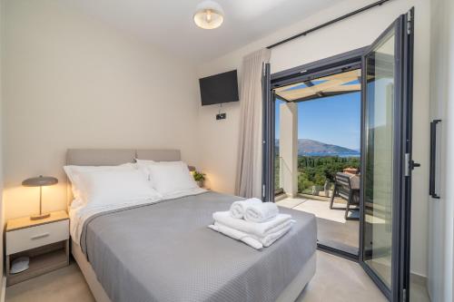 a bedroom with a bed and a balcony with a view at Agemaya Villas in Sami
